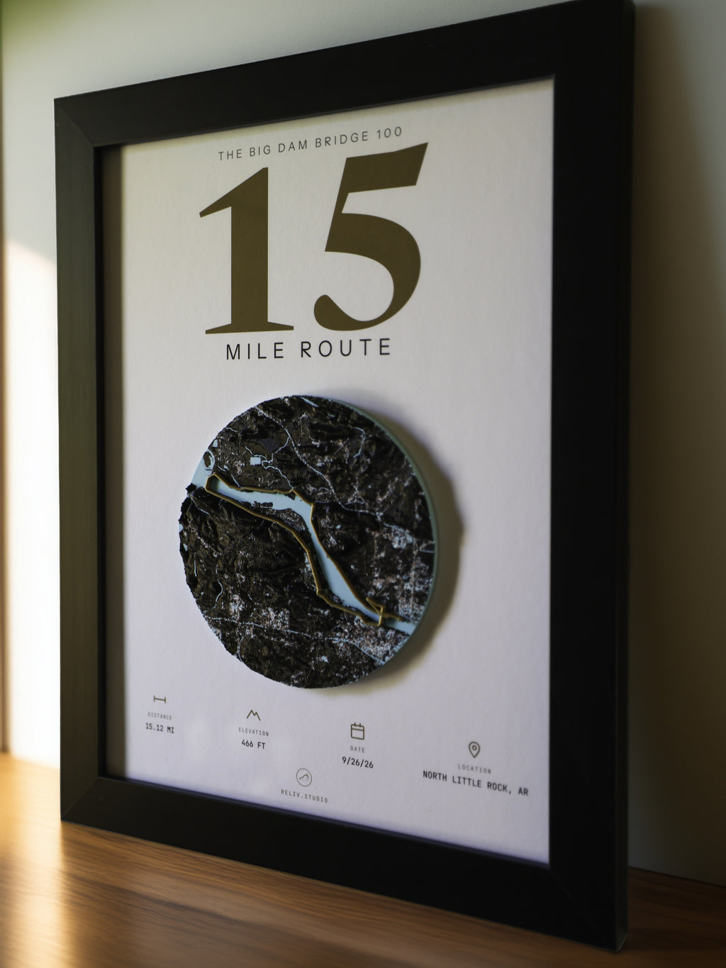 THE MARKER, 15 mile route of the Big Dam Bridge 100 — framed relief map viewed at an angle, showing the raised terrain and the brass route line